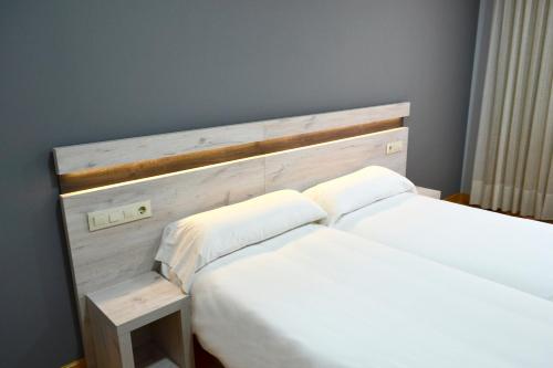 two white beds in a room with a headboard at Hotel Alda Centro Oviedo in Oviedo