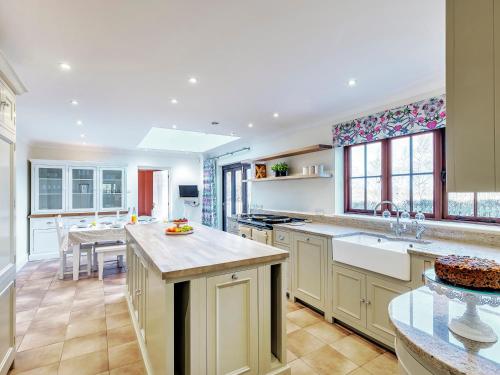 a large kitchen with a large island in the middle at Tuffon Hall Farmhouse in Halstead