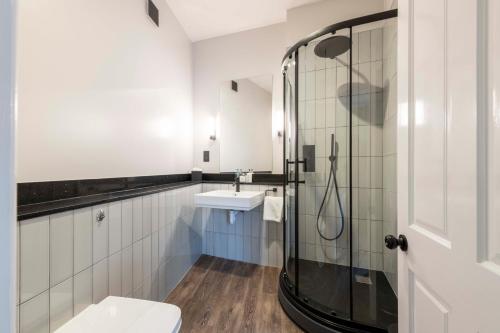 uma casa de banho com um chuveiro, um WC e um lavatório. em Wisteria Hotel em Oakham