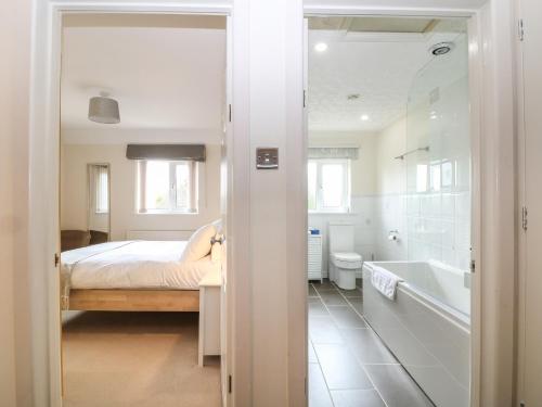 ein Schlafzimmer mit einem Bett und einer Badewanne neben einem Bad in der Unterkunft White Stones in Burford