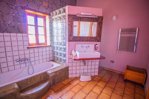 a pink bathroom with a tub and a sink at Mountain Hideaway House in Moya in Moya