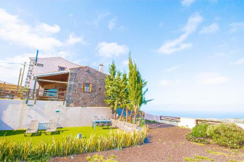 a house with two chairs on the grass near the ocean at Mountain Hideaway House in Moya in Moya
