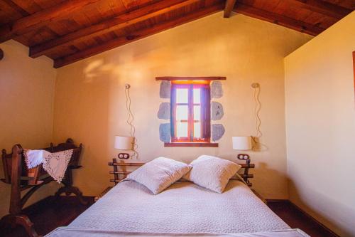 a bedroom with a white bed with a window at Mountain Hideaway House in Moya in Moya
