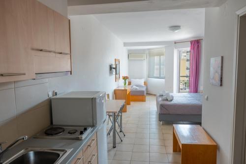 a kitchen with a sink and a living room at Hotel Arethousa in Loutra Edipsou