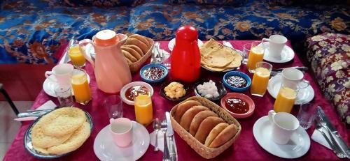 - une table avec petit-déjeuner composé d'œufs et de nourriture dans l'établissement Riad Tifor, à Marrakech