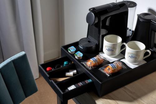 a tray with two coffee cups and a coffee maker at Hotel Villa Romantic & Spa in Paris