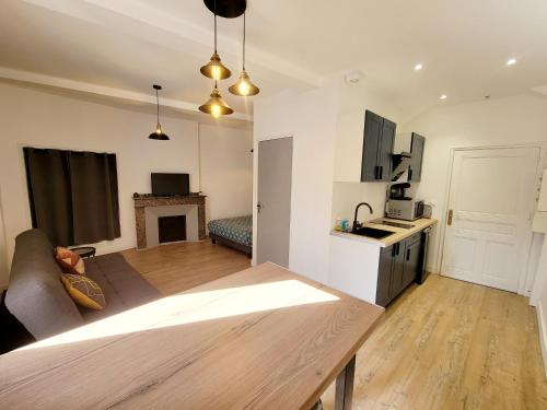 a living room with a couch and a kitchen with a table at Joli Appartement avec balcon clim in Graulhet