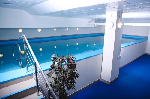 a room with a swimming pool with a plant at SkyPoint Hotel Sheremetyevo Airport in Khimki