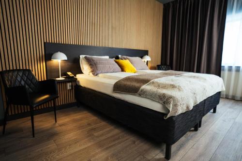 a bedroom with a large bed and a chair at Konvin Hotel by Reykjavik Keflavik Airport in Keflavík