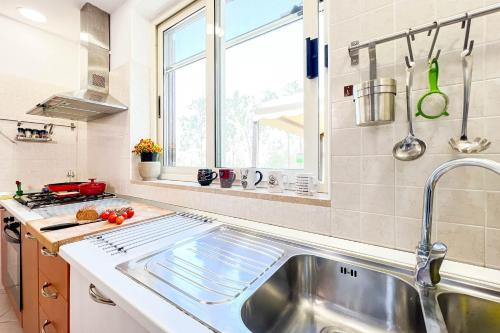 a kitchen with a stainless steel sink and a window at Livingapple in Scauri