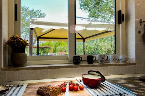 a kitchen with a window and a counter with tomatoes at Livingapple in Scauri