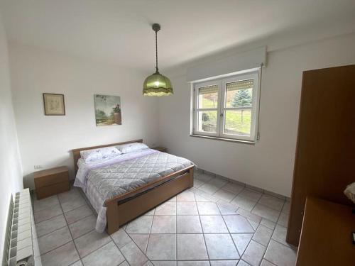 1 dormitorio con cama y ventana en Terra del Sasso Country-house, en Sasso di Castalda