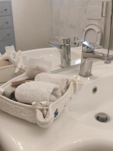 La salle de bains est pourvue d'un lavabo, de serviettes et d'un robinet. dans l'établissement Dépendance in Villa Albachiara e Primaluce, à Carmignano