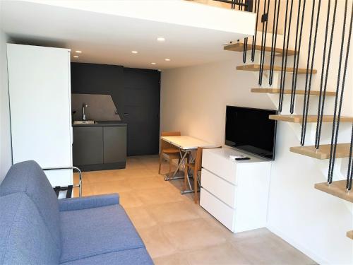 un salon avec un canapé bleu et une télévision dans l'établissement Le duplex proche mer 202, à Nice