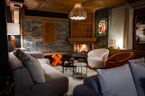 a living room with a couch and a fireplace at Hôtel Névé in Morzine