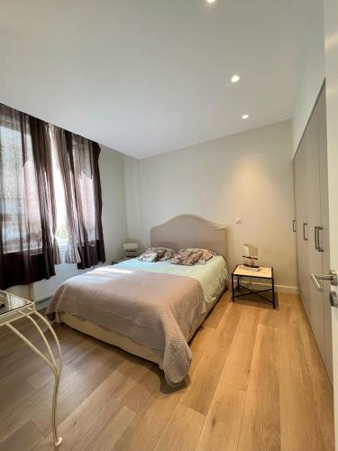 sypialnia z łóżkiem i drewnianą podłogą w obiekcie Le Central Victoria II - Central Point - 55m2 w Nancy