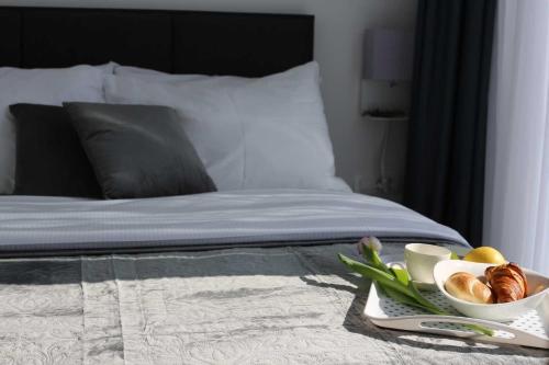 a tray of food on a bed with a plate of food at Premier Laguna Apartment in Lovište