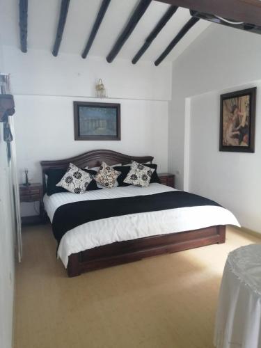 een slaapkamer met een groot bed met zwart-witte kussens bij Beraka Boutique in Villa de Leyva