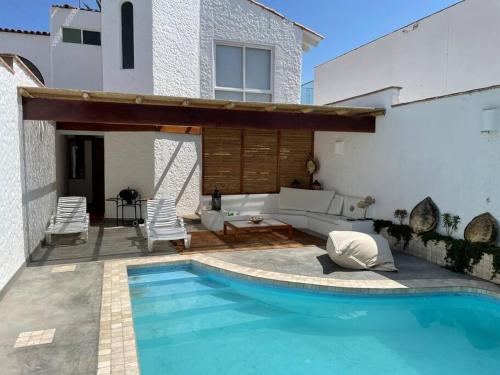 a swimming pool in front of a house at Beachfront, 4BR, entire house in Paracas in Paracas