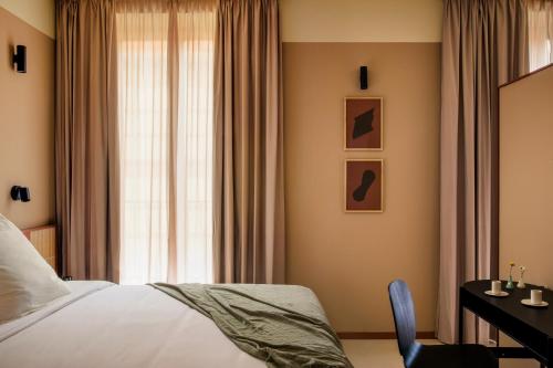 a bedroom with a bed and a desk and a window at CASA Y FONDA 1888 in Alcalá de Henares