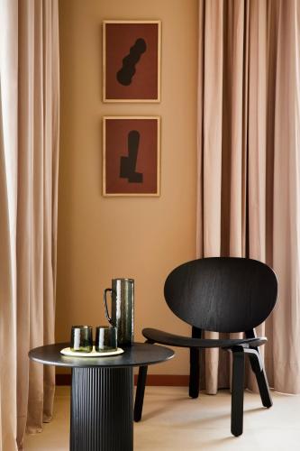 a black chair and a table and a chair and a table at CASA Y FONDA 1888 in Alcalá de Henares