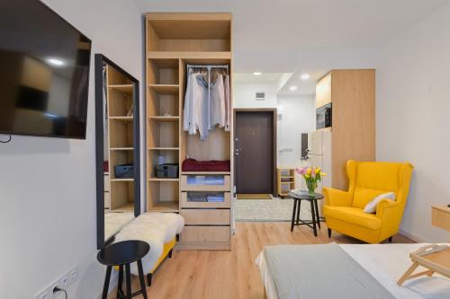 a living room with a closet and a yellow chair at Cosy and Stylish Studio next to Sofia's Central Market Hall in Sofia