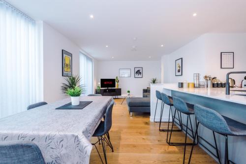 Hilltop Serviced Apartments - Piccadilly في مانشستر: غرفة معيشة مع طاولة وكراسي طويلة