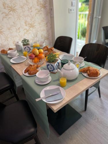 une table avec un tissu de table vert et de la nourriture dans l'établissement chambre suite B&B, à Montpellier