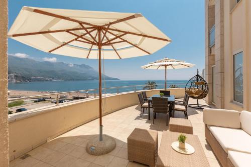 un patio con sombrilla, mesa y sillas en Apartments TQ Splendid, en Budva