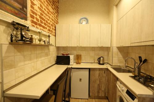 a kitchen with white cabinets and a sink at Luky apartment on Rustaveli Ave. in Tbilisi City