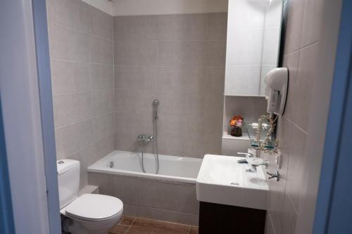 ein Badezimmer mit einem WC, einem Waschbecken und einer Badewanne in der Unterkunft Hotel Arethousa in Loutra Edipsou