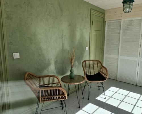two chairs and a table with a vase in a room at Kalakuninga Puhkemaja in Liimala