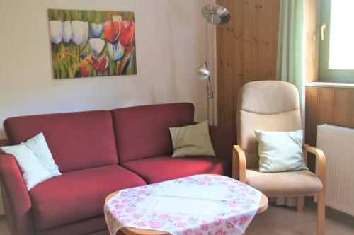 a living room with a red couch and a table at Ferienwohnung Hofmann in Bad Kreuznach