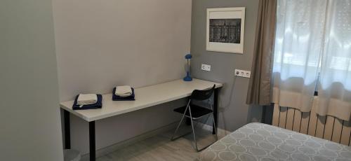 a room with a desk with a chair and a bed at Villa "Luna de Segovia" in Leganés