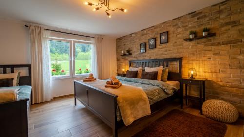 a bedroom with a bed and a brick wall at Holiday Home Lino in Brod Moravice