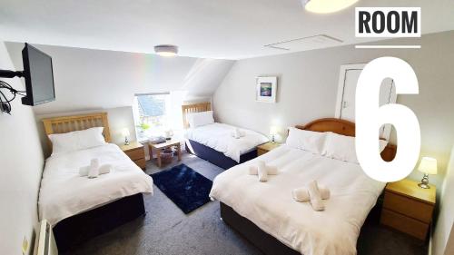 een kamer met 2 bedden en een kamer met 6 borden bij Rooms on the High Street in Portree