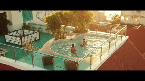 two people in a swimming pool on a balcony at Hotel Isla de Flores in Flores