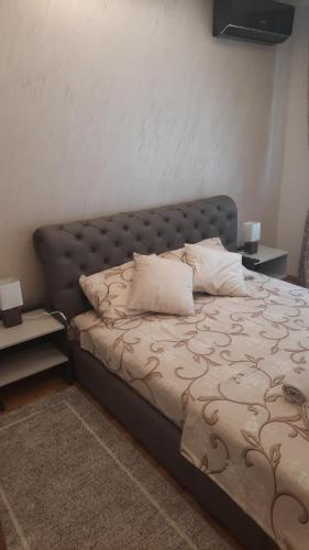 a bedroom with a bed with a leather headboard at Apartman Posejdon Deluxe in Vrnjačka Banja