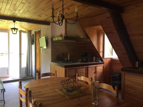 a dining room with a wooden table and a kitchen at Appartement dans grange in Aucun