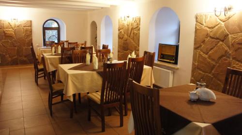 uma sala de jantar com mesas e cadeiras num restaurante em Hotel Stary Młyn em Suchedniów