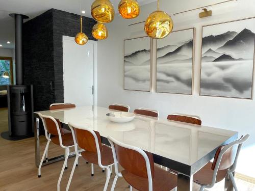 une salle à manger avec une table et des chaises blanches dans l'établissement Les Moutons de Cauterets - garage privé, à Cauterets