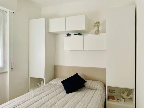 una camera bianca con letto e armadi bianchi di Mamidoli apartment, exclusive area in Chiavari a Chiavari