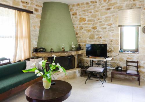 a living room with a couch and a fireplace at Charming Stone House With Swimming Pool in Archanes