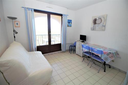 une chambre avec un lit et un bureau avec un ordinateur dans l'établissement TRO91 - Studio cabine vue mer dans une residence avec piscine, à Saint-Cyprien