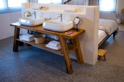 a bathroom with two sinks on a table with a bed at Kushin rooms Split in Split