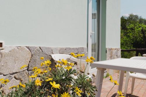 a table and chairs and yellow flowers on a patio at La Quiete in Genova