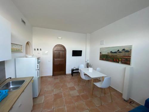 a kitchen and dining room with a table and a refrigerator at Le casette di Frà al Bondì in Santa Severa