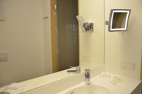 a bathroom with a sink and a large mirror at Seewirt Zauner - contactless check in in Hallstatt