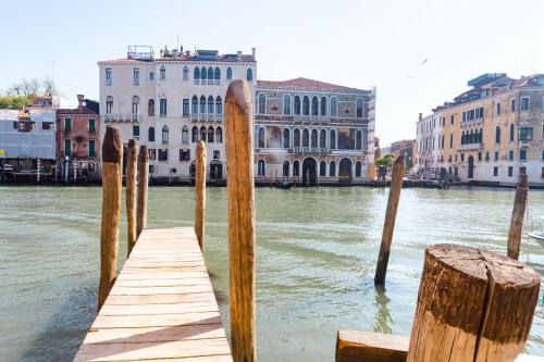 a wooden dock in the water next to buildings at Hotel Dei Dragomanni in Venice