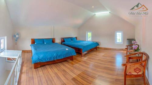 um quarto com 2 camas e piso em madeira em Moonlight Homestay em Da Lat